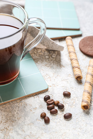 Drink coasters with cup of coffee and sweets on gray grunge tableの写真素材