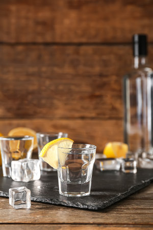 Glass of cold vodka on wooden backgroundの写真素材