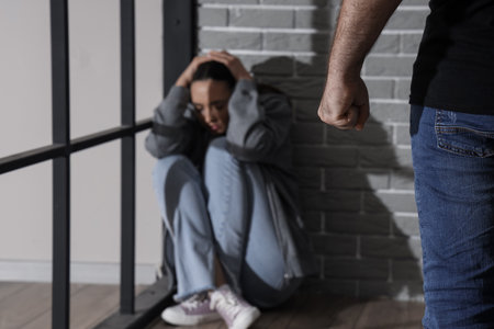 Young man with clenched fist and his scared wife at home, closeup. domestic violence conceptの写真素材