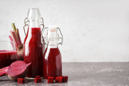 Bottles of fresh beetroot juice on grunge background