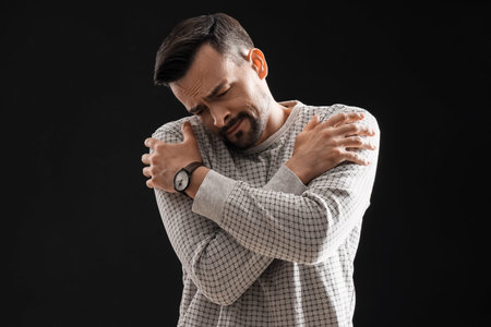 Young man having panic attack on black background