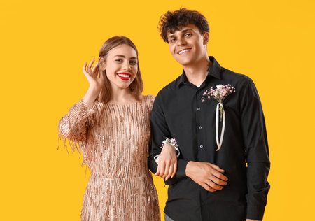 Beautiful prom couple on yellow backgroundの写真素材