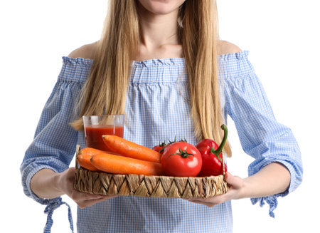 Young woman with glass of juice and vegetables on white background, closeupの写真素材