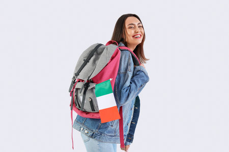 Young woman with flag of Italy and backpack on white backgroundの写真素材