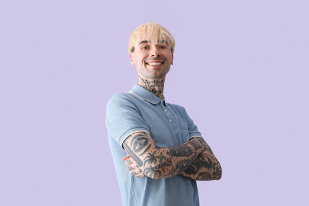 Tattooed young man on lilac backgroundの写真素材