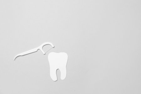 Floss toothpick and tooth model on gray backgroundの写真素材