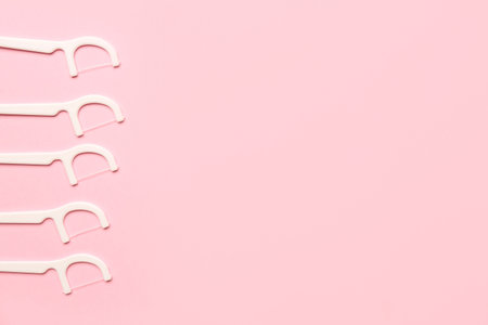 Floss toothpicks on pink backgroundの写真素材