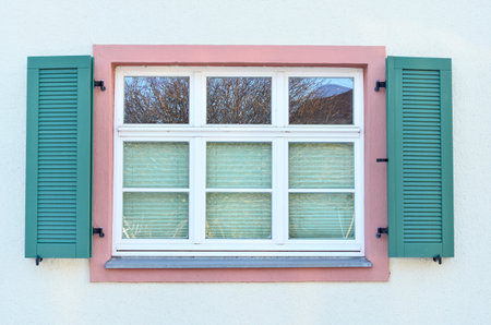 View of white building with wooden window and shuttersの写真素材