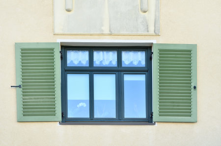 View of residential building with wooden window and shutters