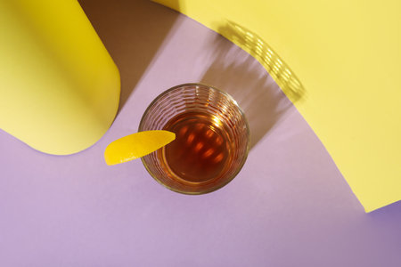 Glass of rum with lemon slice on colorful backgroundの写真素材