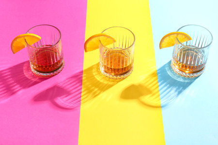 Glasses of rum with orange slices on colorful backgroundの写真素材