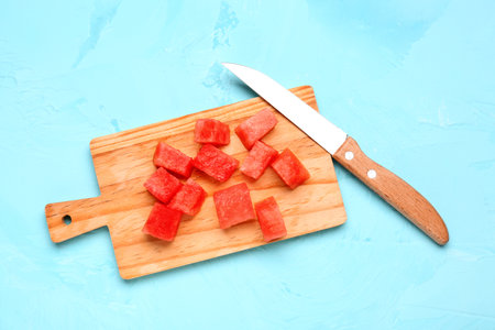 Board with pieces of fresh watermelon on blue backgroundの写真素材