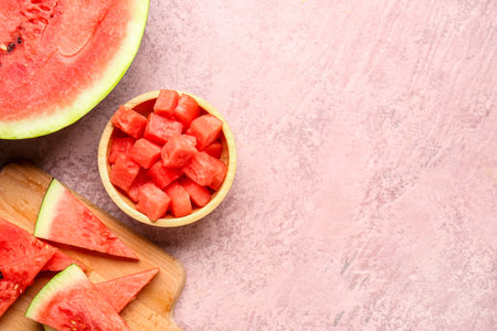 Board and bowl with pieces of fresh watermelon on pink backgroundの写真素材