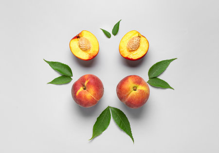 Sweet peaches and leaves on gray backgroundの写真素材