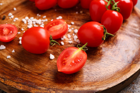 Wooden plate with fresh cherry tomatoes, closeupの写真素材