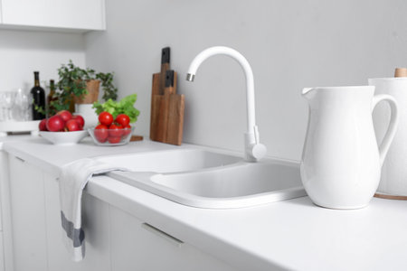 White countertop with sink and vegetables in modern kitchenの写真素材