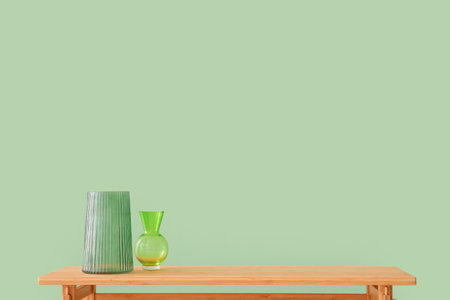Wooden table with empty vases near green wallの写真素材
