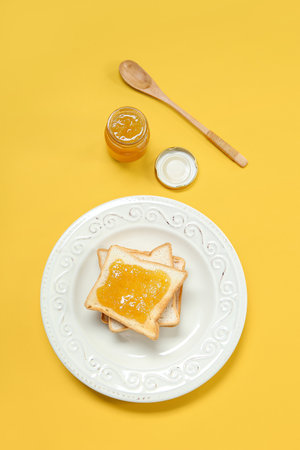 Plate of tasty toasts and jam on color backgroundの写真素材