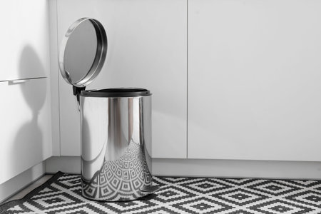 Opened metallic trash bin in interior of modern kitchen