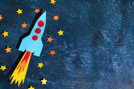 Blue paper rocket with stars on dark grunge backgroundの写真素材