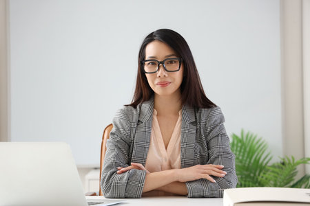 Beautiful Asian businesswoman in stylish eyeglasses in officeの写真素材