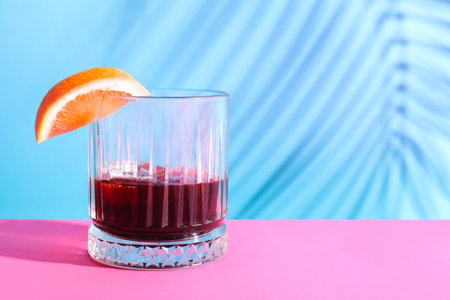 Glass of rum with grapefruit slice on pink and blue backgroundの写真素材