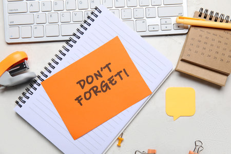 Don't forget reminder with stationery, computer keyboard and calendar on white backgroundの写真素材