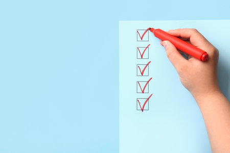 Woman marking on checklist box with red markerの写真素材