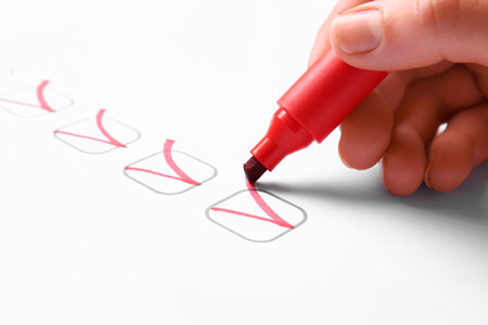 Woman marking on checklist box with red marker, closeupの素材 [FY310207116617]