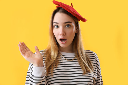 Shocked young woman on yellow background, closeupの写真素材