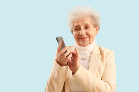 Senior woman using mobile phone on blue background