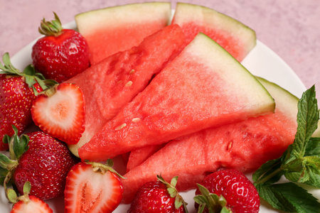 Plate with pieces of fresh watermelon and strawberries, closeupの写真素材