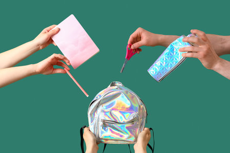 People with backpack and school stationery on green background