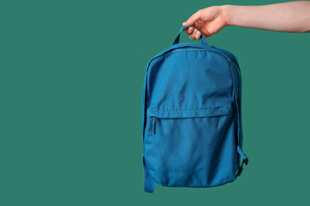 Man with schoolbag on green background
