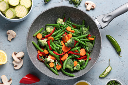 Frying pan with fresh vegetables on gray backgroundの写真素材