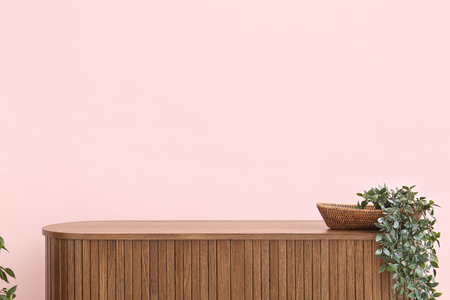 Modern chest of drawers with houseplant near pink wall in roomの写真素材