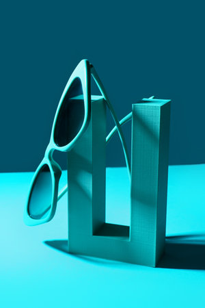 Podium with stylish sunglasses on blue backgroundの素材 [FY310207077049]