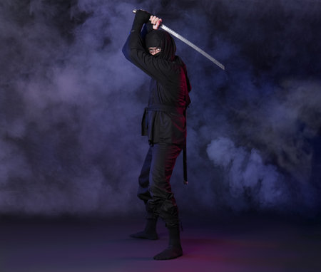 Male ninja with sword on dark backgroundの写真素材