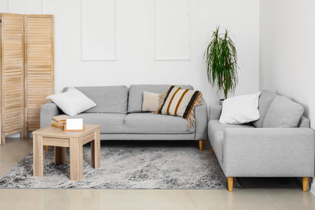Interior of living room with cozy gray sofas and wooden coffee table