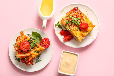 Plates of pasta with tomato sauce and cheese on pink backgroundの写真素材