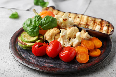 Plate with grilled vegetables and basil on gray backgroundの写真素材