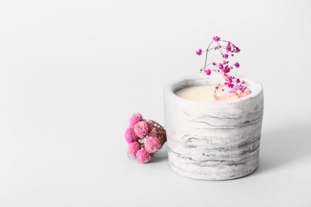 Holder with candle and flowers on white backgroundの写真素材