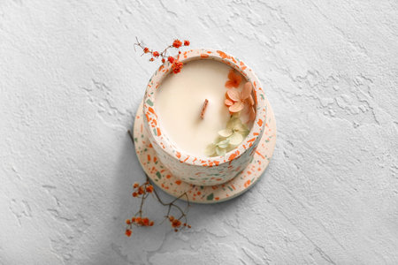 Holder with candle and flowers on blue backgroundの写真素材