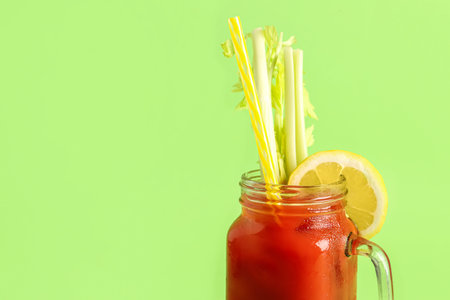 Mason jar of bloody mary with celery and lemon on green backgroundの写真素材