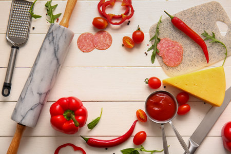 Frame made of ingredients for preparing pizza on light wooden backgroundの写真素材