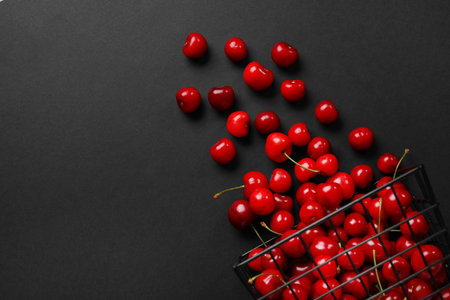 Basket with sweet cherry on black backgroundの写真素材