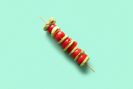 Skewer with tasty grilled vegetables on turquoise backgroundの写真素材