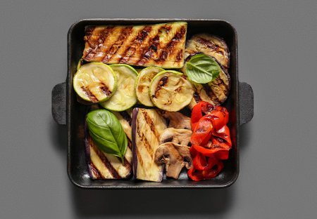 Baking dish with tasty grilled vegetables on dark backgroundの写真素材
