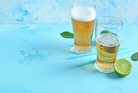Glasses of cold beer with lime on blue backgroundの写真素材