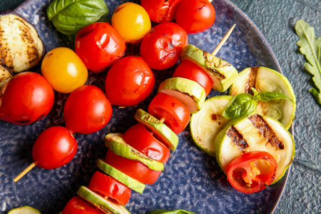 Plate with tasty grilled vegetables on blue backgroundの写真素材